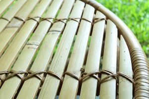 Closeup of bamboo table top with blurry green lawn in the backdrop